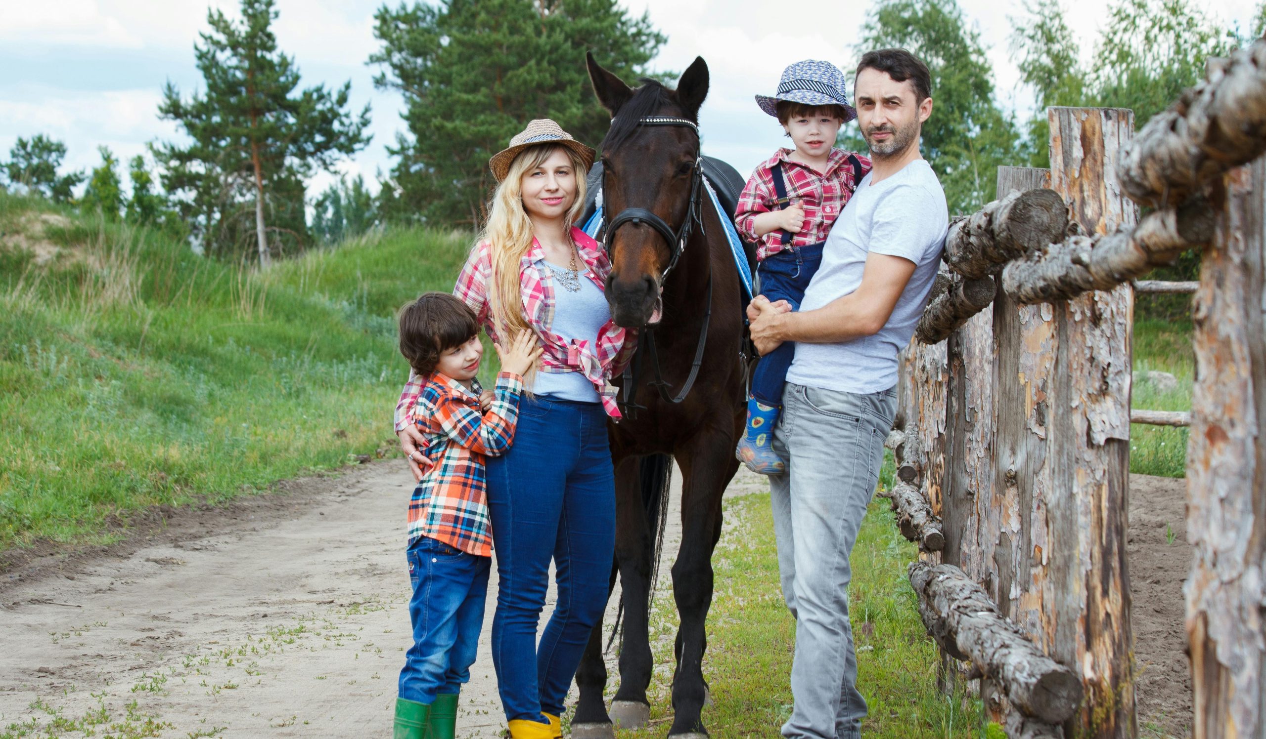 Family bonding outdoors with a horse, capturing joyful moments in a scenic countryside setting.